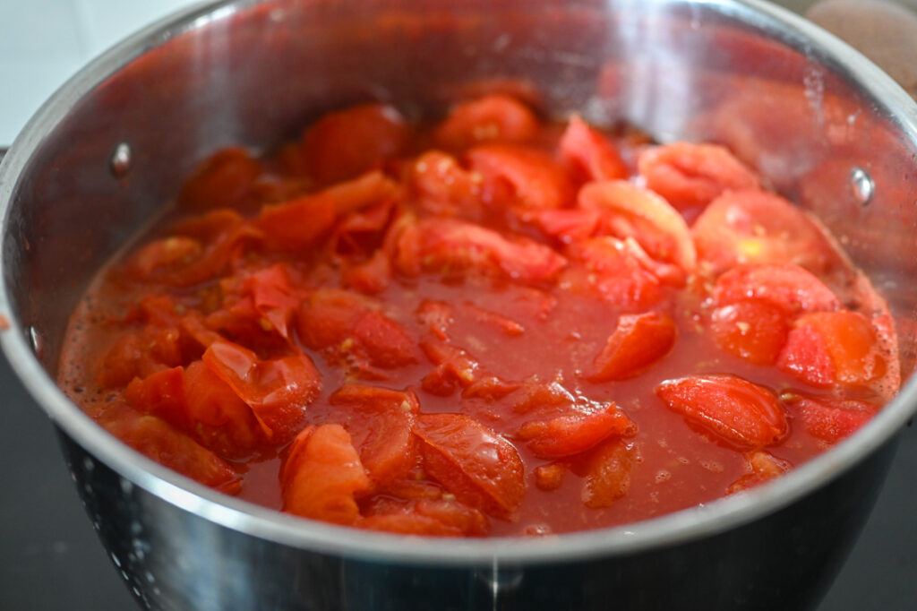 Tomaten im Topf zerfallen beim Kochen und Wasser tritt aus